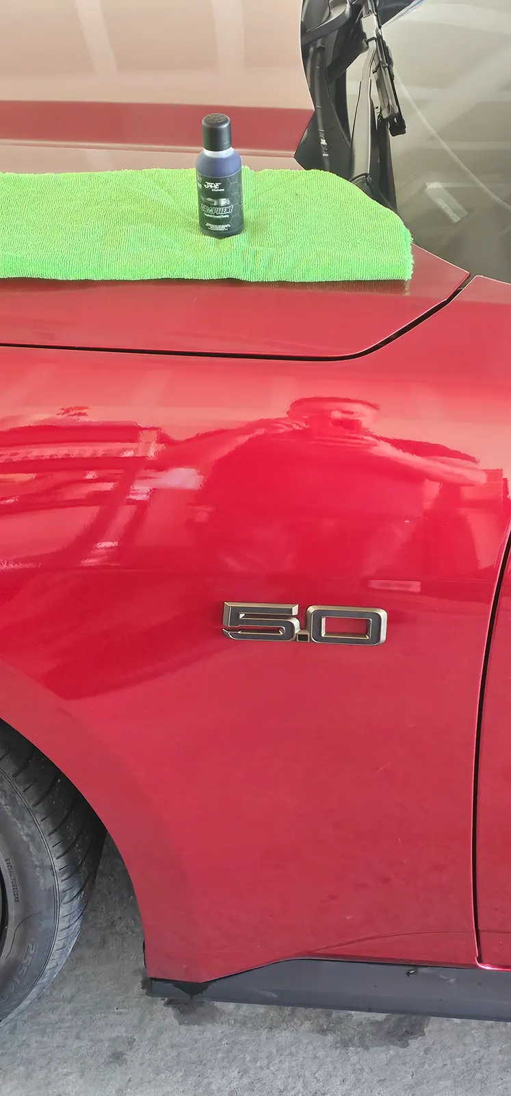 Deep gloss on the flank of a red Mustang GT after a ceramic coating