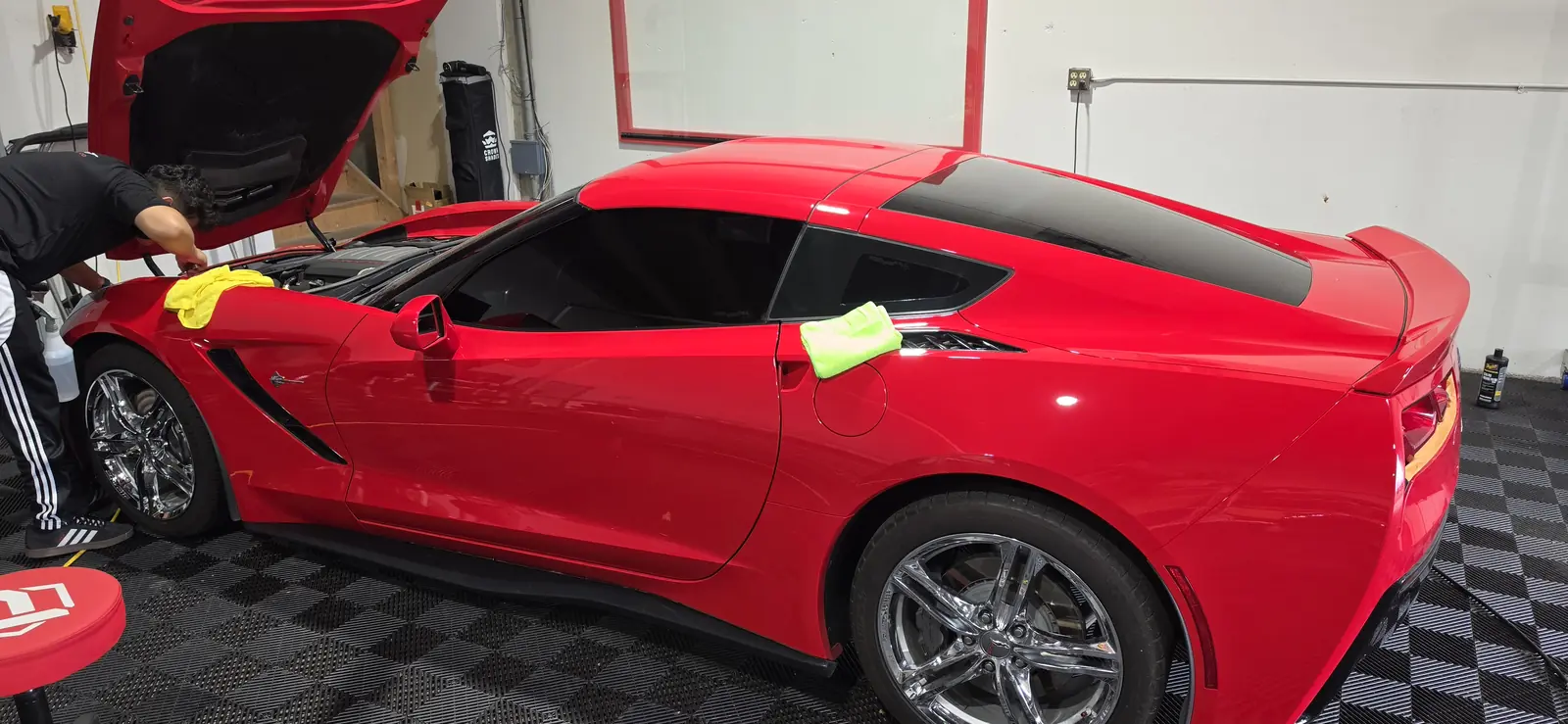 Ceramic coating being worked across the front end of a red Corvette Stingray