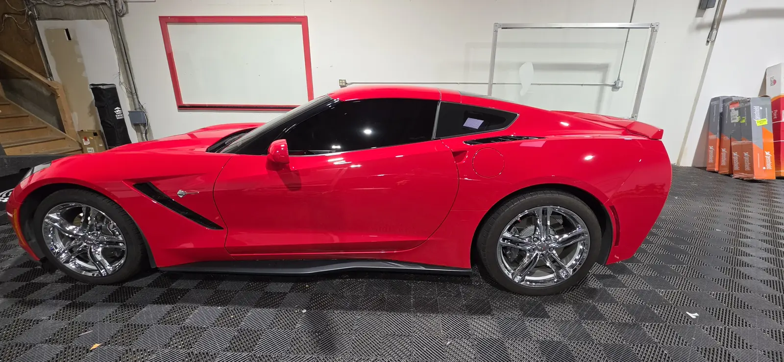Red Corvette Stingray finished after a ceramic coating, side profile in the shop