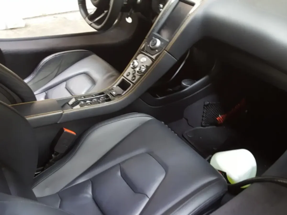 Spotless leather interior of a McLaren after a full detail, console and seats cleaned