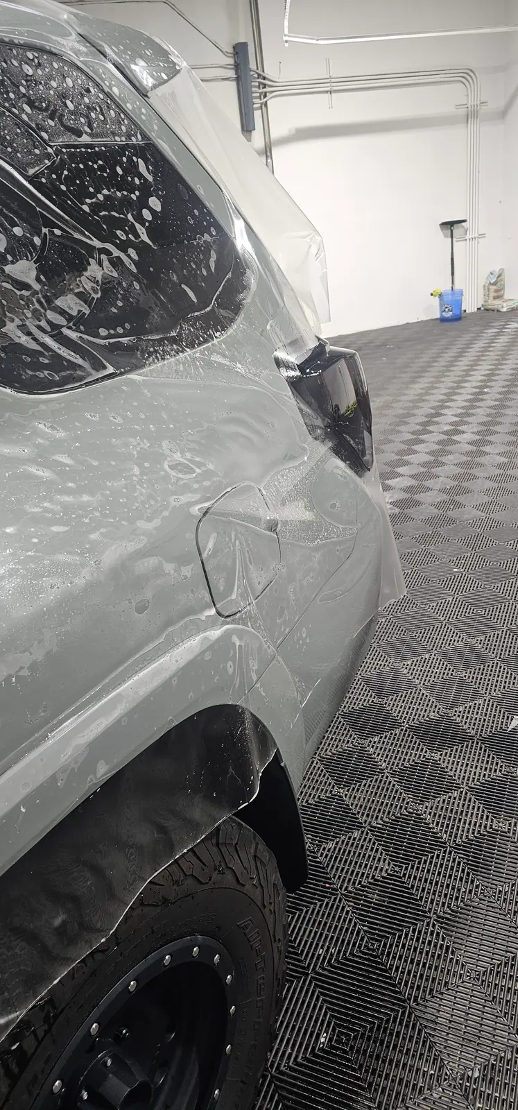 Paint protection film being squeegeed onto the front end of a Toyota 4Runner